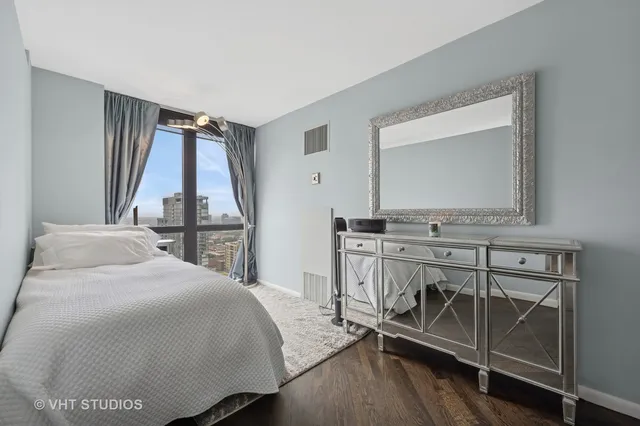 a bedroom with a bed a mirror and a table in it