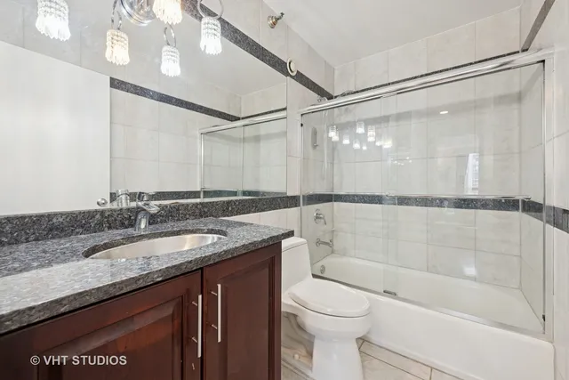 a bathroom with a granite countertop sink mirror toilet and bathtub