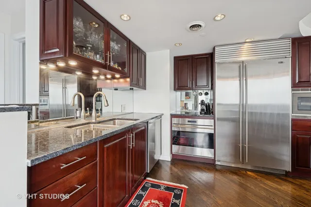 a kitchen with stainless steel appliances granite countertop a sink and a refrigerator