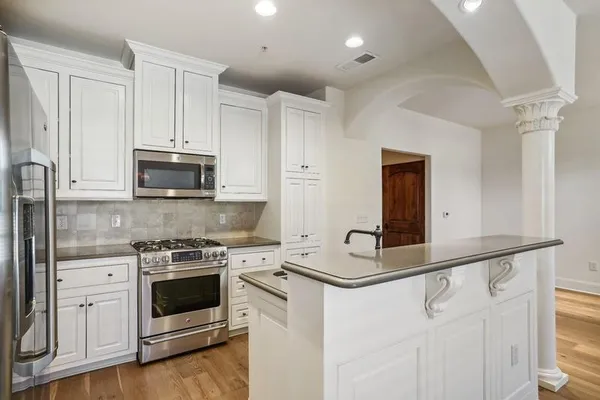 a kitchen with stainless steel appliances a white stove top oven and a refrigerator