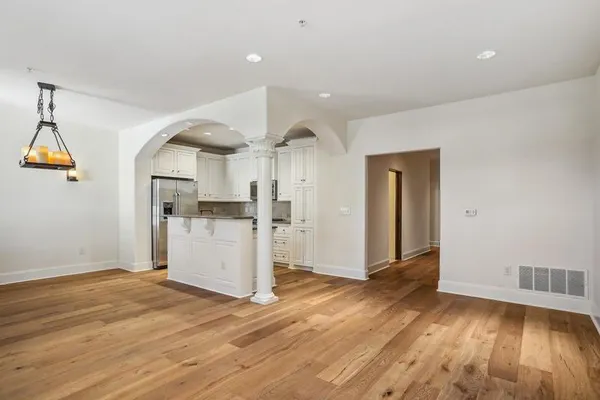 a view of a kitchen with wooden floor and a window