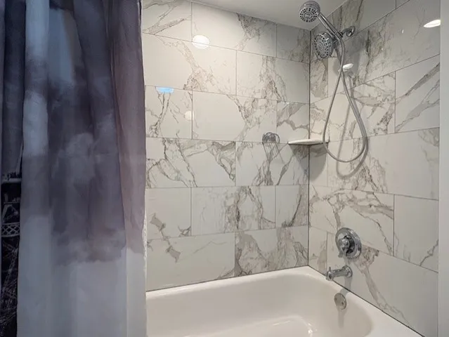 a bathroom with a bathtub and shower