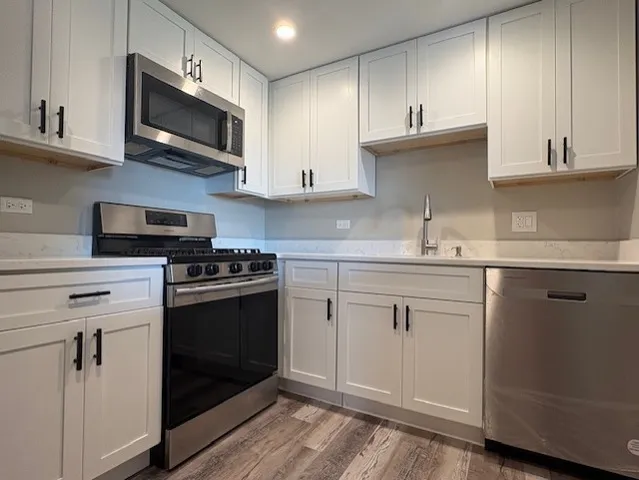 a kitchen with stainless steel appliances granite countertop a sink a stove a microwave and cabinets