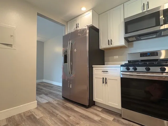 a kitchen with stainless steel appliances a refrigerator stove and microwave