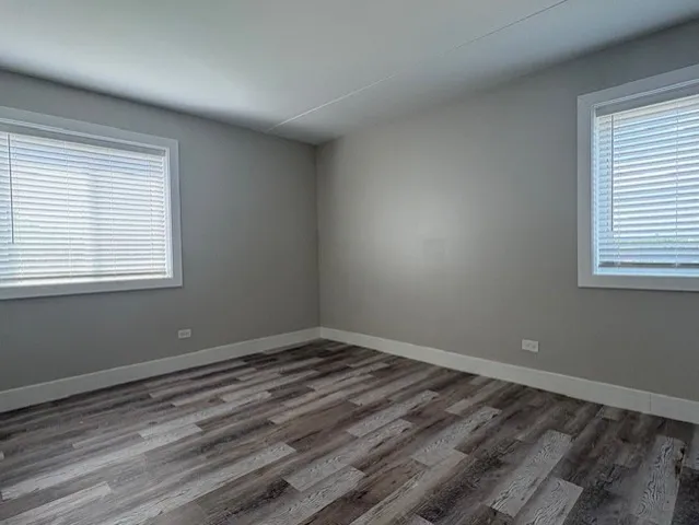a view of a room with wooden floor and windows