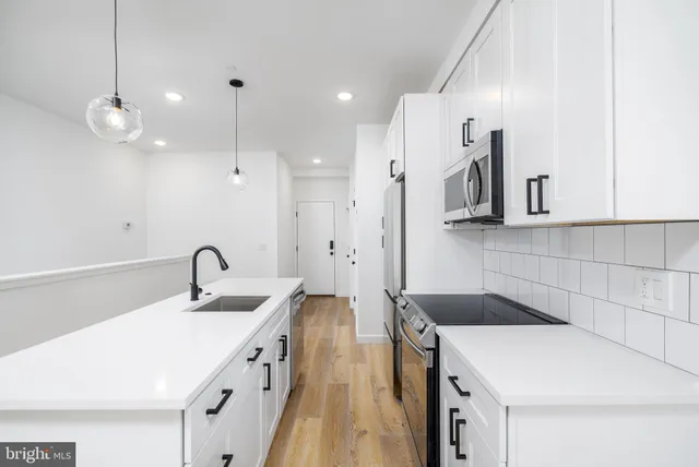 a kitchen with a sink appliances and cabinets