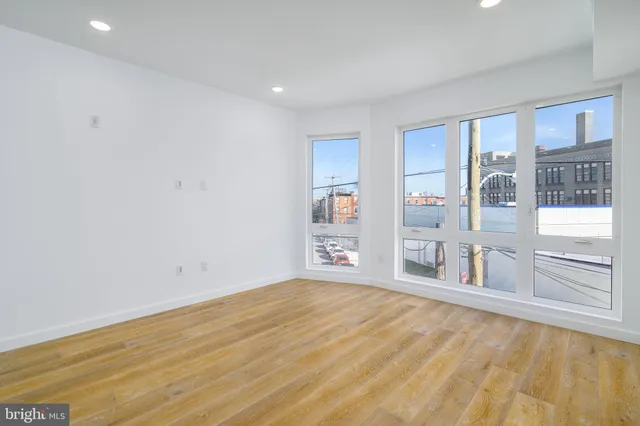 a big room with wooden floor and windows