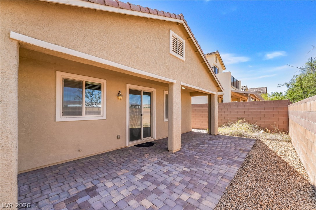 6245 Andover Wood Road Las Vegas, NV 89113 - Photo 33 of 37 A spacious covered patio with paver flooring extends into a low-maintenance yard.