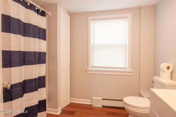 a bathroom with a toilet a sink and a window