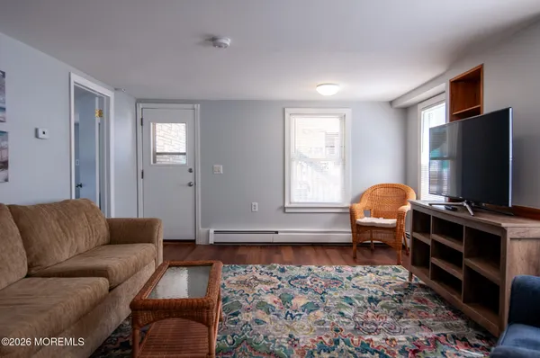 a living room with furniture a flat screen tv and a window