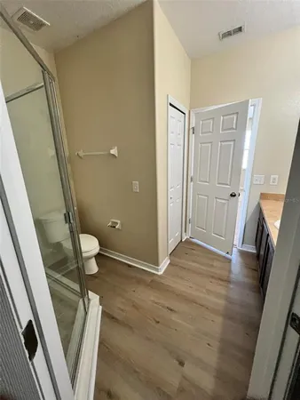 a bathroom with a granite countertop shower and a toilet