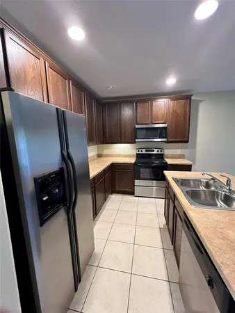 a kitchen with kitchen island granite countertop a stove sink and cabinets