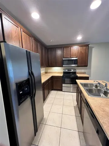 a kitchen with kitchen island granite countertop a stove sink and cabinets