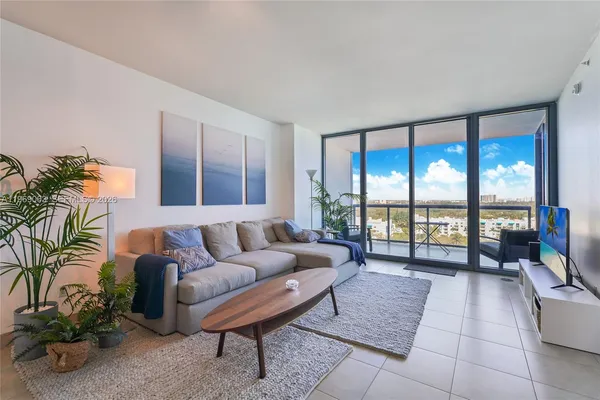 a living room with furniture and a floor to ceiling window