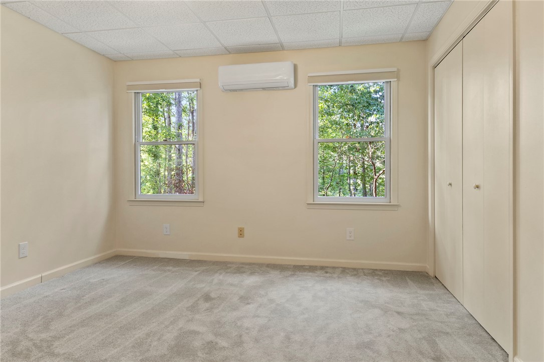 225 Arrowhead Trail Easley, SC 29642 - Photo 20 of 33 This spacious bedroom features ample natural light and plush carpeting, creating a comfortable living space.