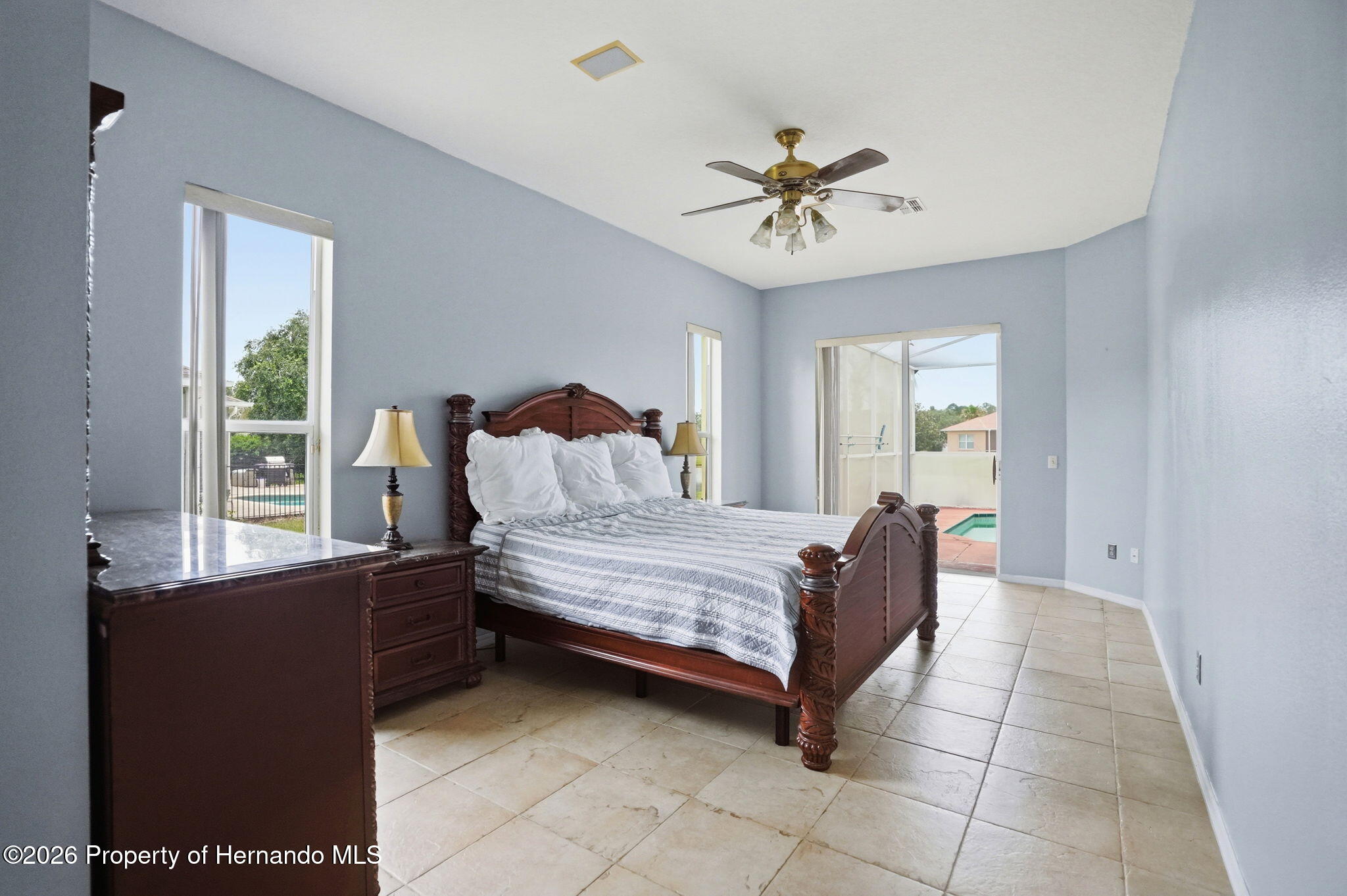 18131 Rivard Boulevard Brooksville, FL 34604 - Photo 25 of 66 a bedroom with a bed and a chandelier