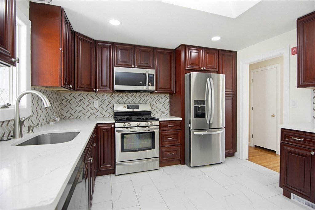 31 Spring Lane Sharon, MA 02067 - Photo 11 of 33 a kitchen with stainless steel appliances granite countertop a refrigerator stove and sink