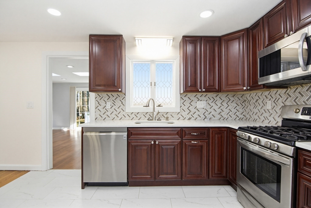 31 Spring Lane Sharon, MA 02067 - Photo 12 of 33 a kitchen with stainless steel appliances granite countertop wooden cabinets and a stove top oven