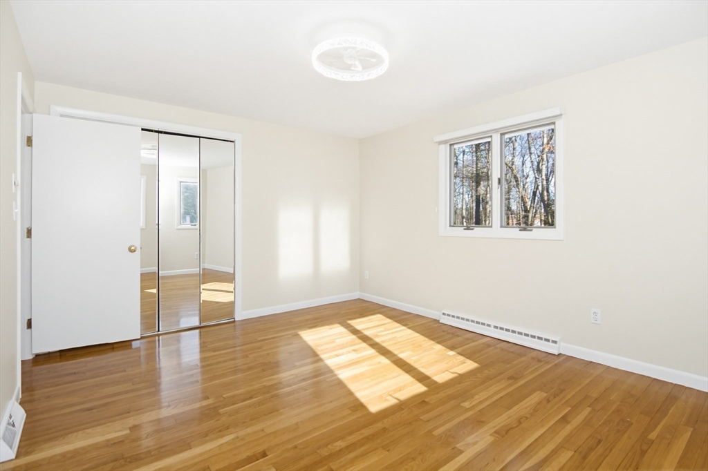 31 Spring Lane Sharon, MA 02067 - Photo 18 of 33 a view of an empty room with wooden floor and a window