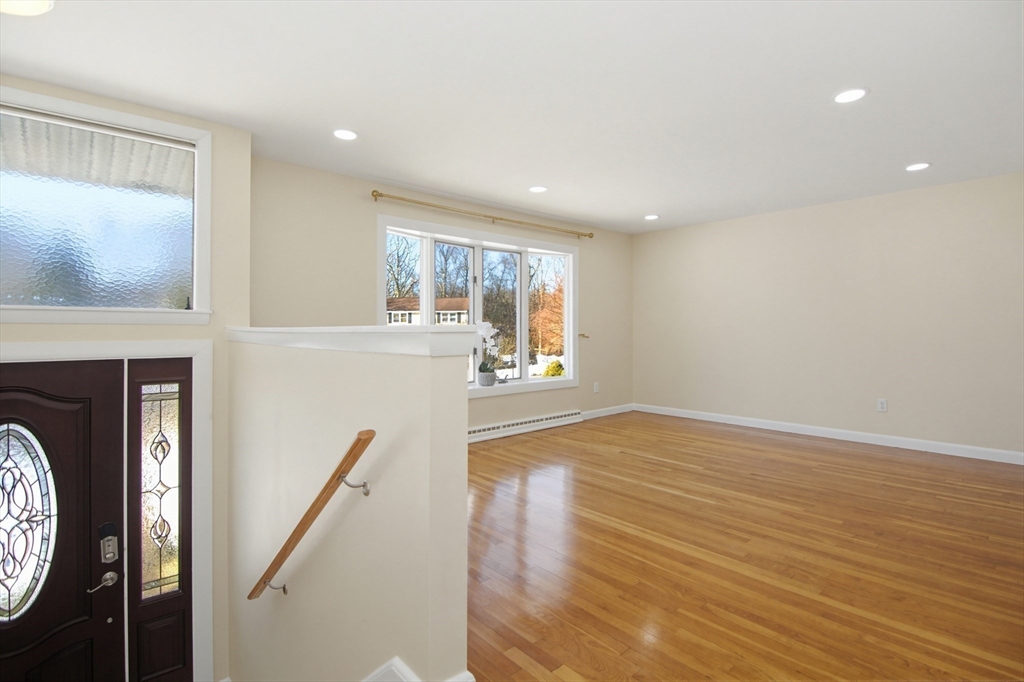 31 Spring Lane Sharon, MA 02067 - Photo 7 of 33 a view of a hallway with wooden floor and a fireplace