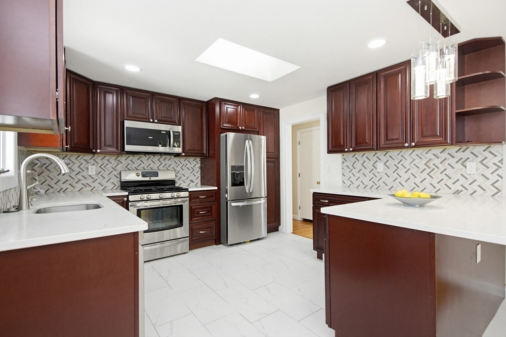 31 Spring Lane Sharon, MA 02067 - Photo 10 of 33 a kitchen with kitchen island a sink stainless steel appliances and cabinets