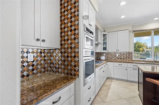 a kitchen with sink and a large mirror