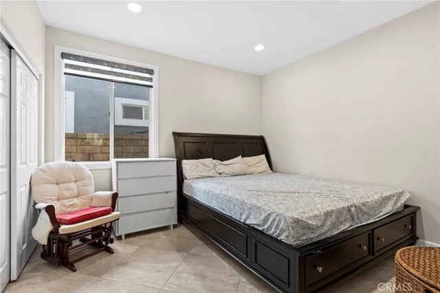 a spacious bedroom with a bed and wooden floor