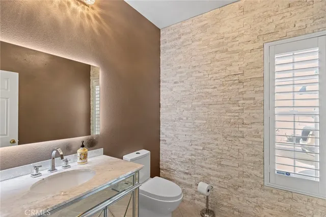 a bathroom with a sink mirror vanity and toilet
