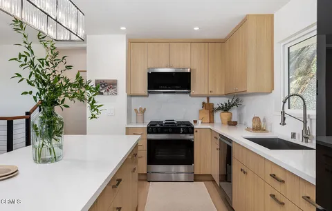 a kitchen with a sink a stove and cabinets