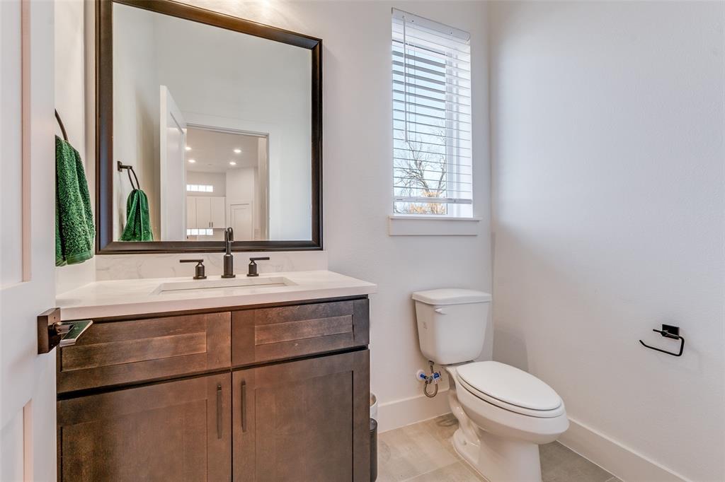 2134 Shea Road, Unit 1001 Dallas, TX 75235 - Photo 12 of 12 a bathroom with a toilet a sink and a mirror