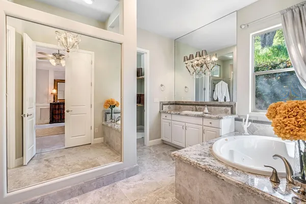 a bathroom with a granite countertop sink a large mirror and a window