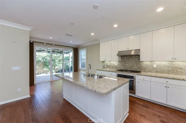 a kitchen with stainless steel appliances granite countertop a sink stove and cabinets