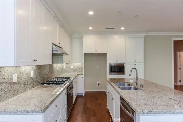 a kitchen with a stove sink and cabinets