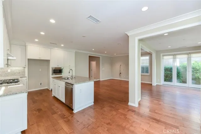 a kitchen with stainless steel appliances kitchen island granite countertop a stove and a refrigerator
