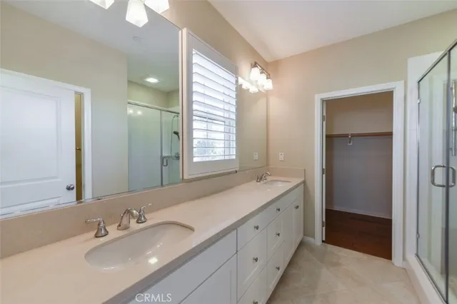 a bathroom with double sink and a mirror