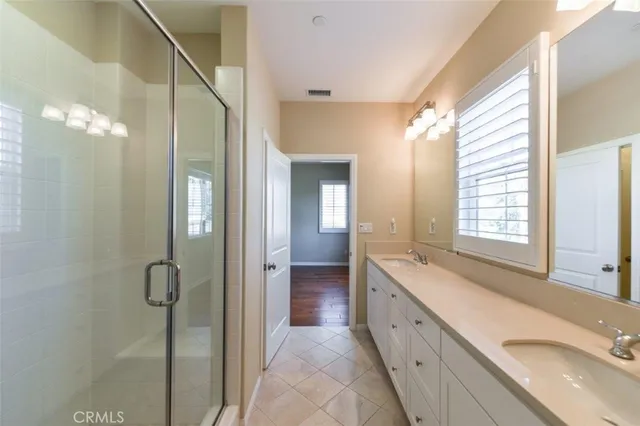 a spacious bathroom with a double vanity sink mirror and shower