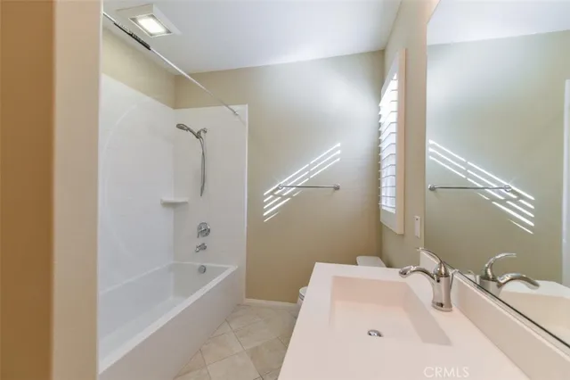 a bathroom with a tub sink and mirror
