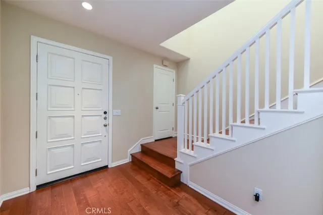 wooden floor with staircase and white walls