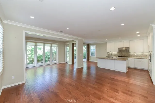 a large kitchen with stainless steel appliances granite countertop a large counter top a sink and a large window