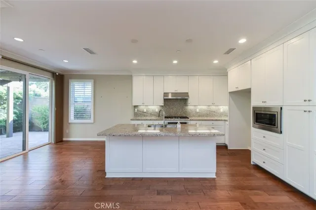 a kitchen with stainless steel appliances granite countertop a stove a sink and a refrigerator