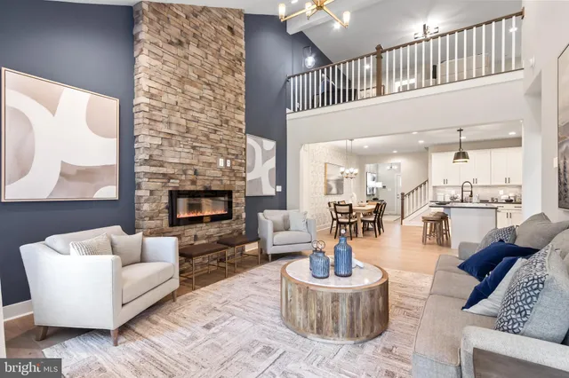 a living room with stainless steel appliances a table and chairs in it