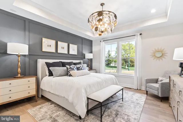 a bedroom with a bed and a chandelier