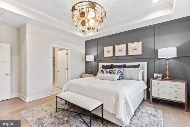 a bedroom with a large bed and a chandelier