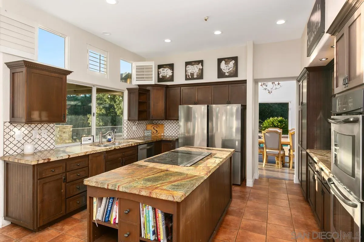 14550 Hidden Wood Road Jamul, CA 91935 - Photo 17 of 51 a kitchen with stainless steel appliances granite countertop a refrigerator a stove and a sink with wooden floor