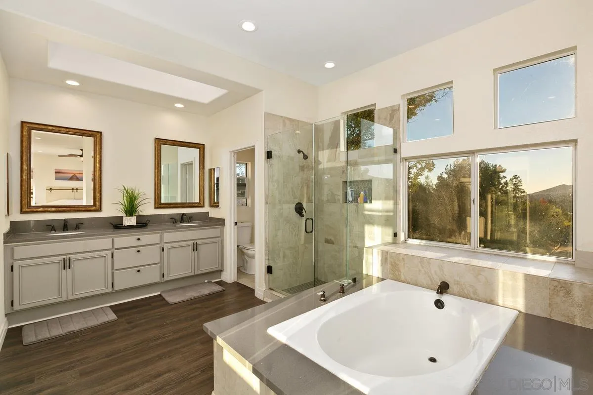 14550 Hidden Wood Road Jamul, CA 91935 - Photo 23 of 51 a bathroom with a sink a large mirror and a bathtub