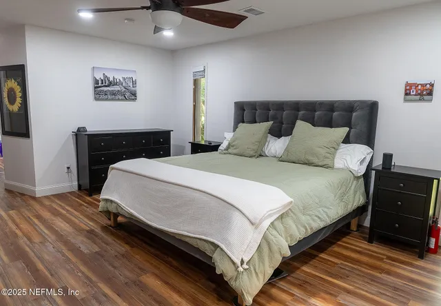 a bedroom with a bed and a lamp on dresser