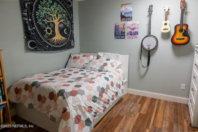 a bedroom with a bed and painting on the wall