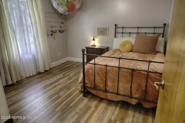 a bedroom with a bed and wooden floor