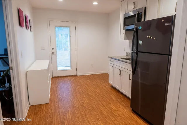 a kitchen with a refrigerator and a stove top oven