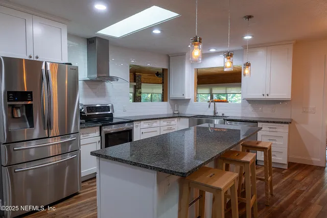 a kitchen with kitchen island a counter space a sink and stainless steel appliances